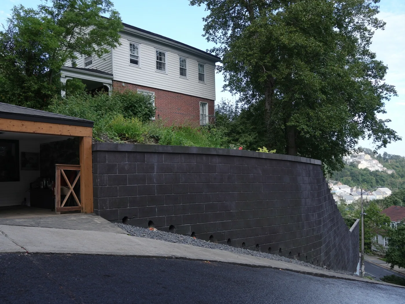 Segmental block retaining wall holding a hillside yard above a street in Pittsburgh, Pennsylvania
